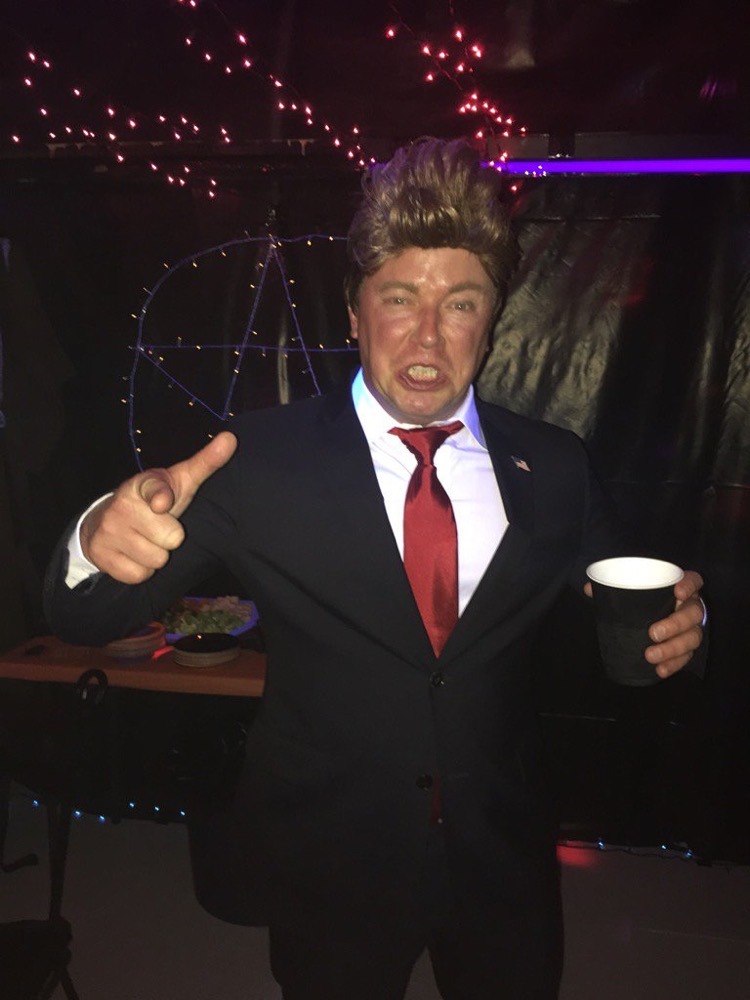 Author in Donald Trump costume defiantly pointing